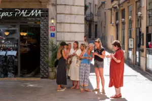 Grupo disfrutando de un tour gastronómico autoguiado por el casco antiguo de Palma durante una experiencia culinaria.