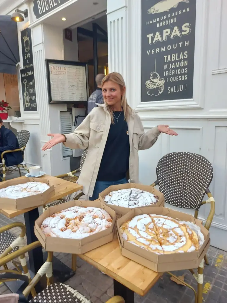 Ensaïmadas tradicionales expuestas en mesas de una cafetería al aire libre en Mallorca